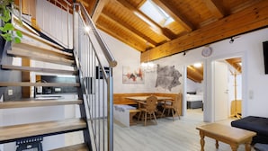 Un interior moderno con una escalera de madera, un comedor y una sala de estar.
