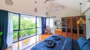 Un dormitorio amplio con una cama grande, un armario de madera y un ventilador de techo.
