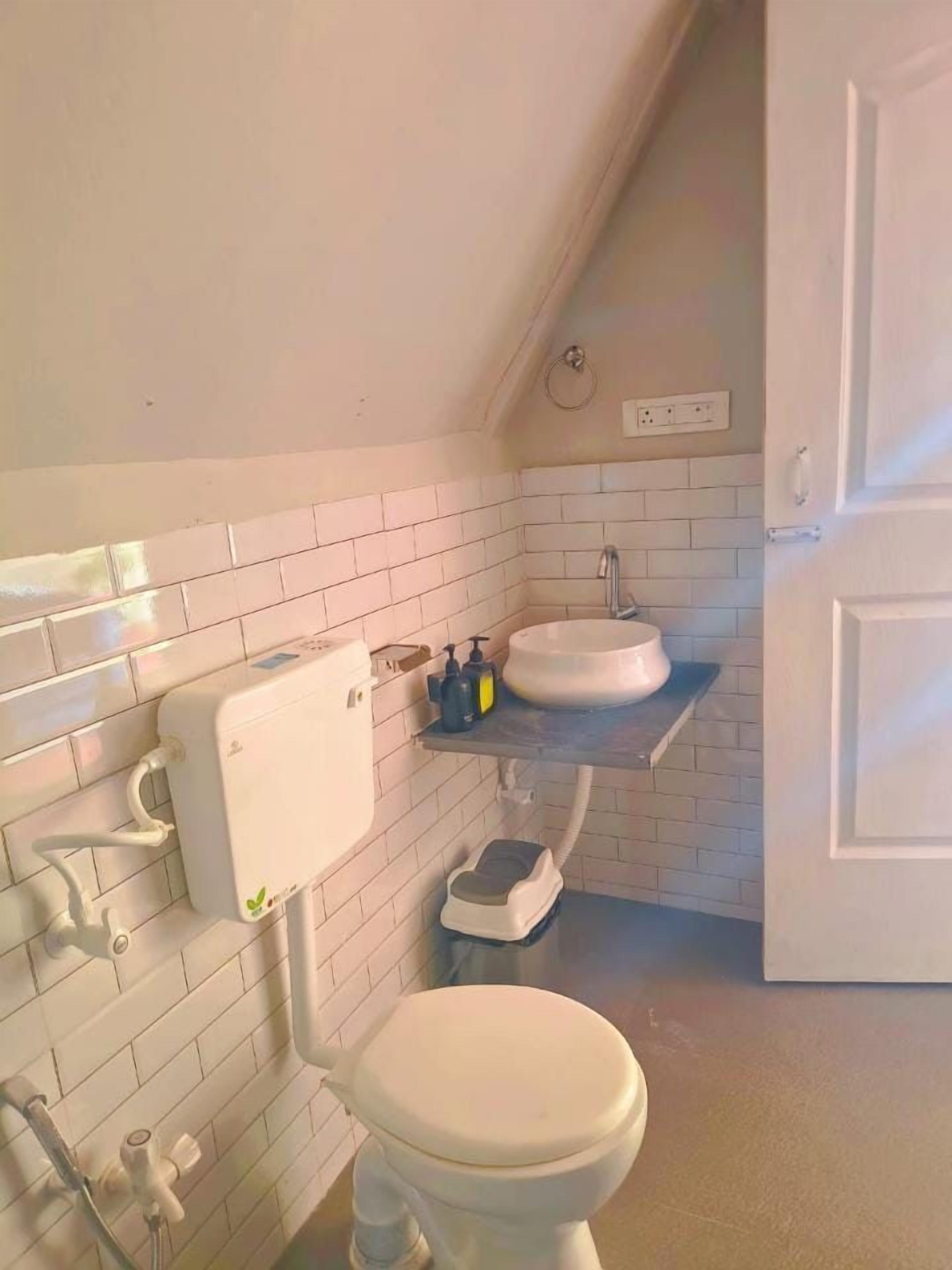 Un baño con inodoro, lavabo y dispensador de papel higiénico.