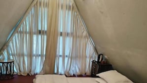 A room with a bed, a small table, and a chair. - Rustic Palms - Restaurant & Cabins (Alibag)