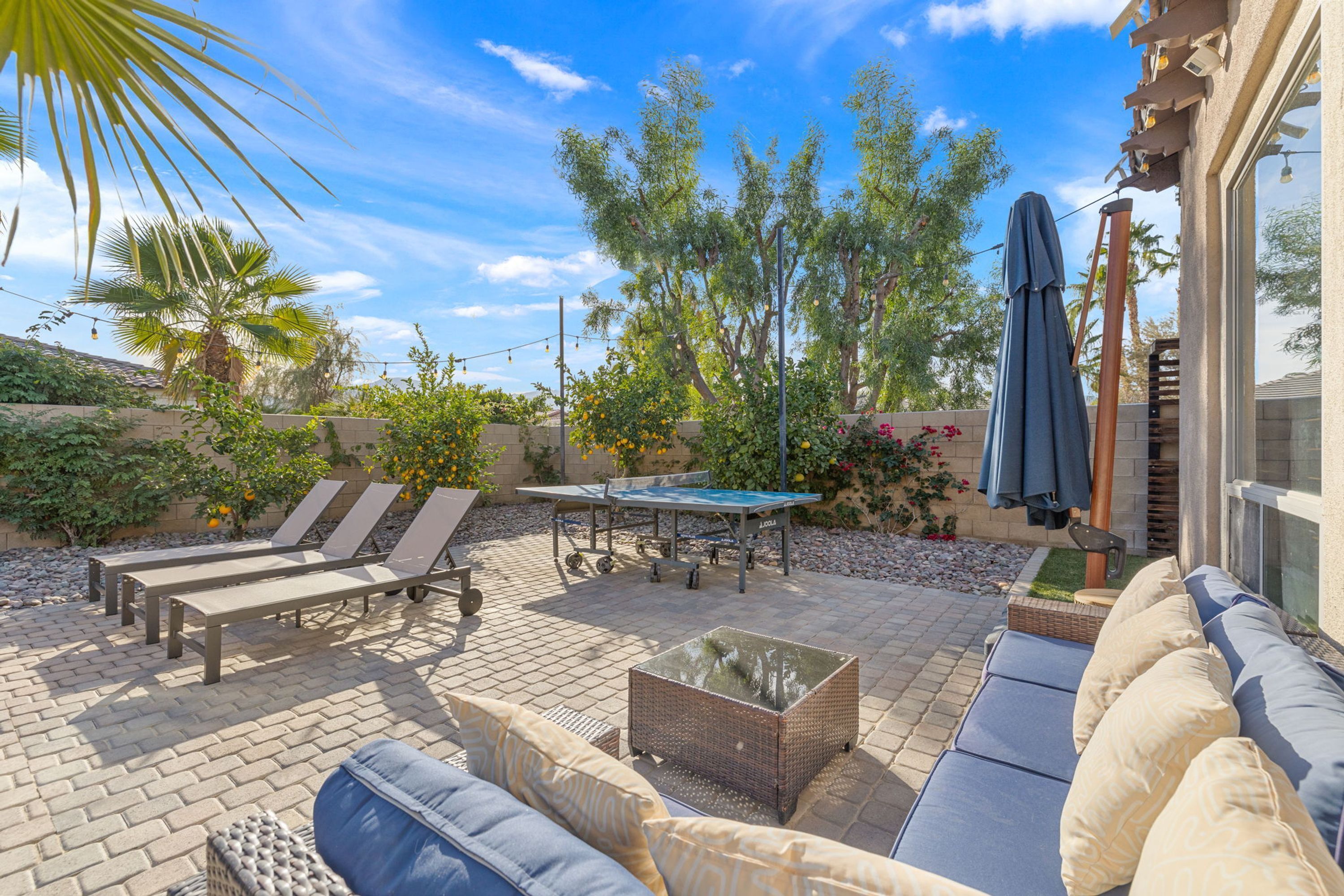 A patio with outdoor furniture, a table, and a pool.