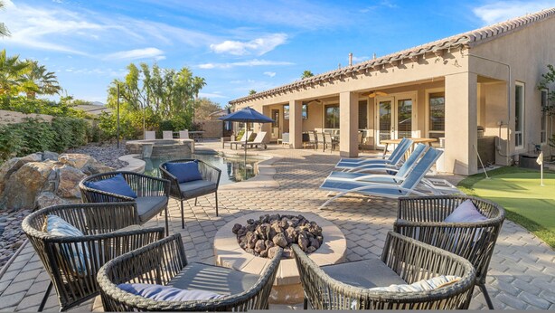 An outdoor patio with wicker furniture, a fire pit, and a pool area. - Relaxing Vacay Pool Spa Fire Pit Family Games (Indio)