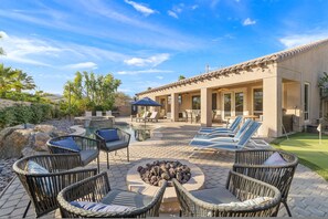 An outdoor patio with wicker furniture, a fire pit, and a pool area. - Relaxing Vacay Pool Spa Fire Pit Family Games (Indio)