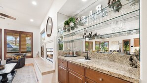A kitchen with a granite countertop, wooden cabinets, and a glass backsplash. - Relaxing Vacay Pool Spa Fire Pit Family Games (Indio)