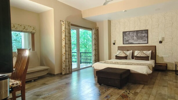 Un dormitorio con una cama grande, una silla, una mesita y vistas al exterior.