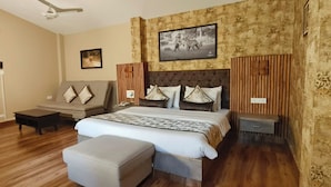 Un dormitorio con una cama, un sofá, una mesita y una mesilla de noche.