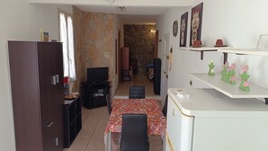 Un espacio habitable compacto con kitchenette, comedor y dormitorio.