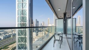 A balcony with a city view, featuring two tables and chairs. - Elegant 1BR Apartment, Rooftop 360° Infinity Pool with Burj Views (Dubai)
