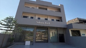 Um edifício moderno com uma placa que diz "Sukoon B&B".