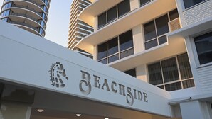 A building with a sign reading "BEACHSIDE" and a logo above it. - Absolute Beachfront Apartment with Direct Pool & Beach Access (Main Beach)