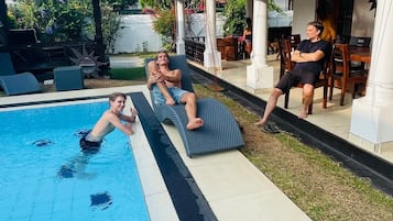 Una piscina con lettini e una zona patio coperta.