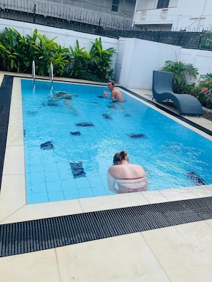 A swimming pool with a tiled edge, a drain, and a lounge chair. - Ayana Beach Garden (Negombo)
