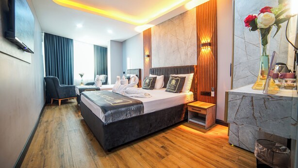 Una habitación de hotel moderna con una cama grande, mesitas de noche, un escritorio y un baño.