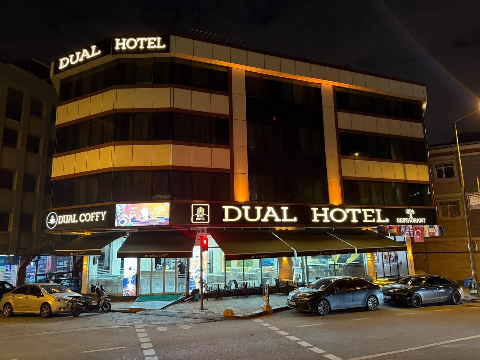 A hotel with a prominent sign reading "DUAL HOTEL" and a "DUAL COFFY" sign below.