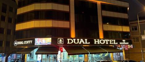 A hotel with a prominent sign reading "DUAL HOTEL" and a "DUAL COFFY" sign below.