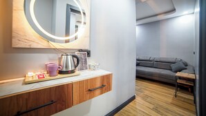 Una habitación moderna con un armario de madera, una cafetera y una bandeja con tazas y una tetera.