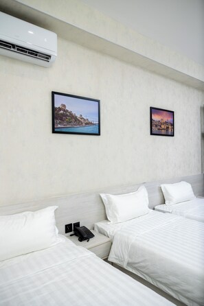 A hotel room with two beds, a phone on the nightstand, and two framed pictures on the wall. - Marmaris Saray Hotel (Tashkent)
