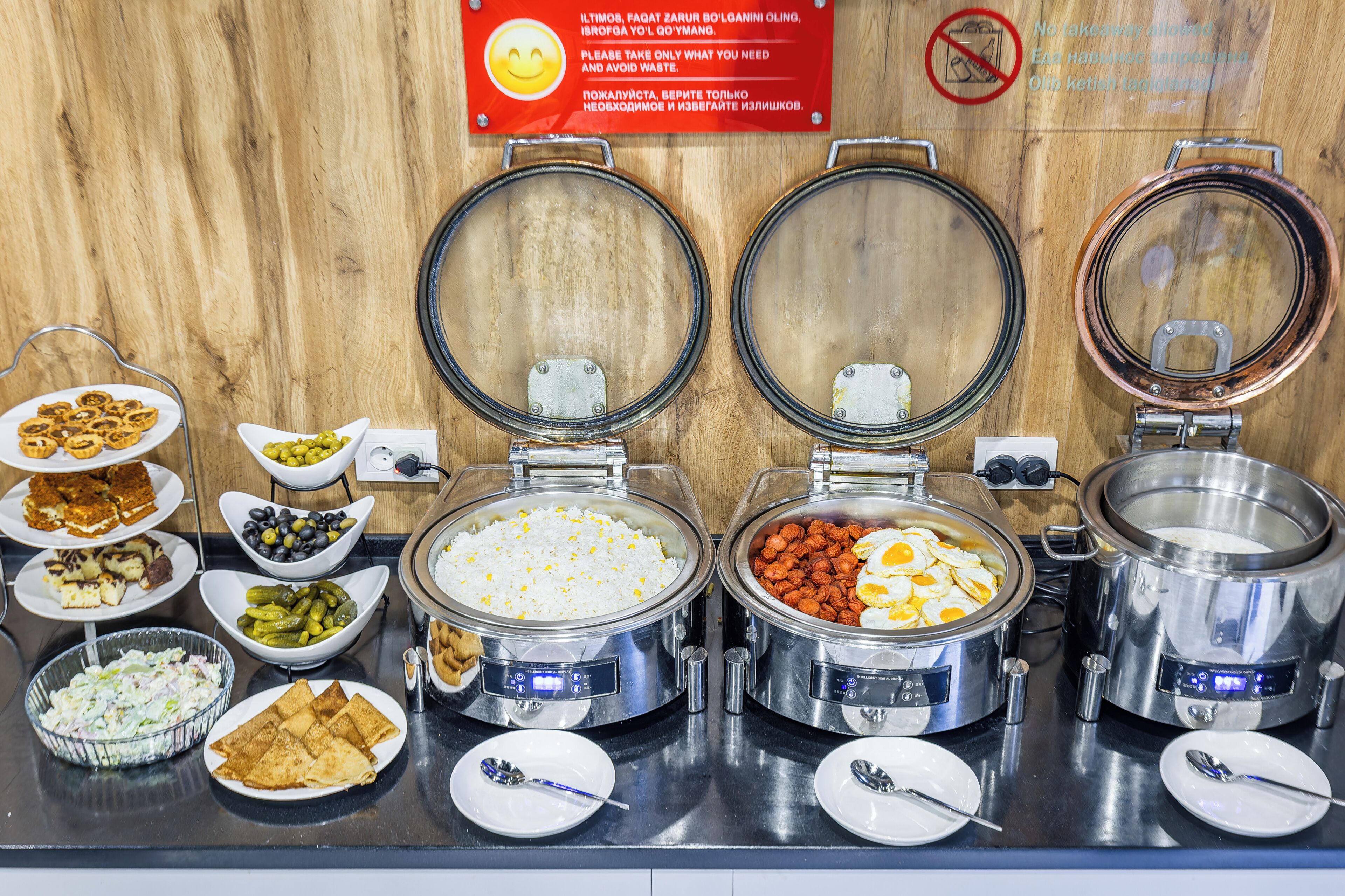 A buffet with various food items including rice, eggs, and salads.