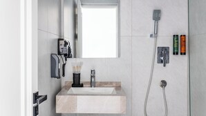 A modern bathroom with a sink, mirror, shower, and toiletries. - Marmaris Saray Hotel (Tashkent)