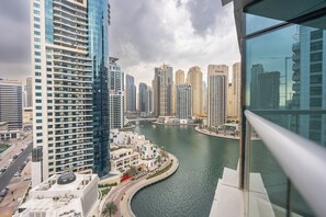Un edificio de gran altura con un río al frente y otros edificios altos al fondo.