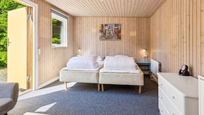 Une chambre avec deux lits, un plafond en bois, un tableau, un bureau et une chaise.