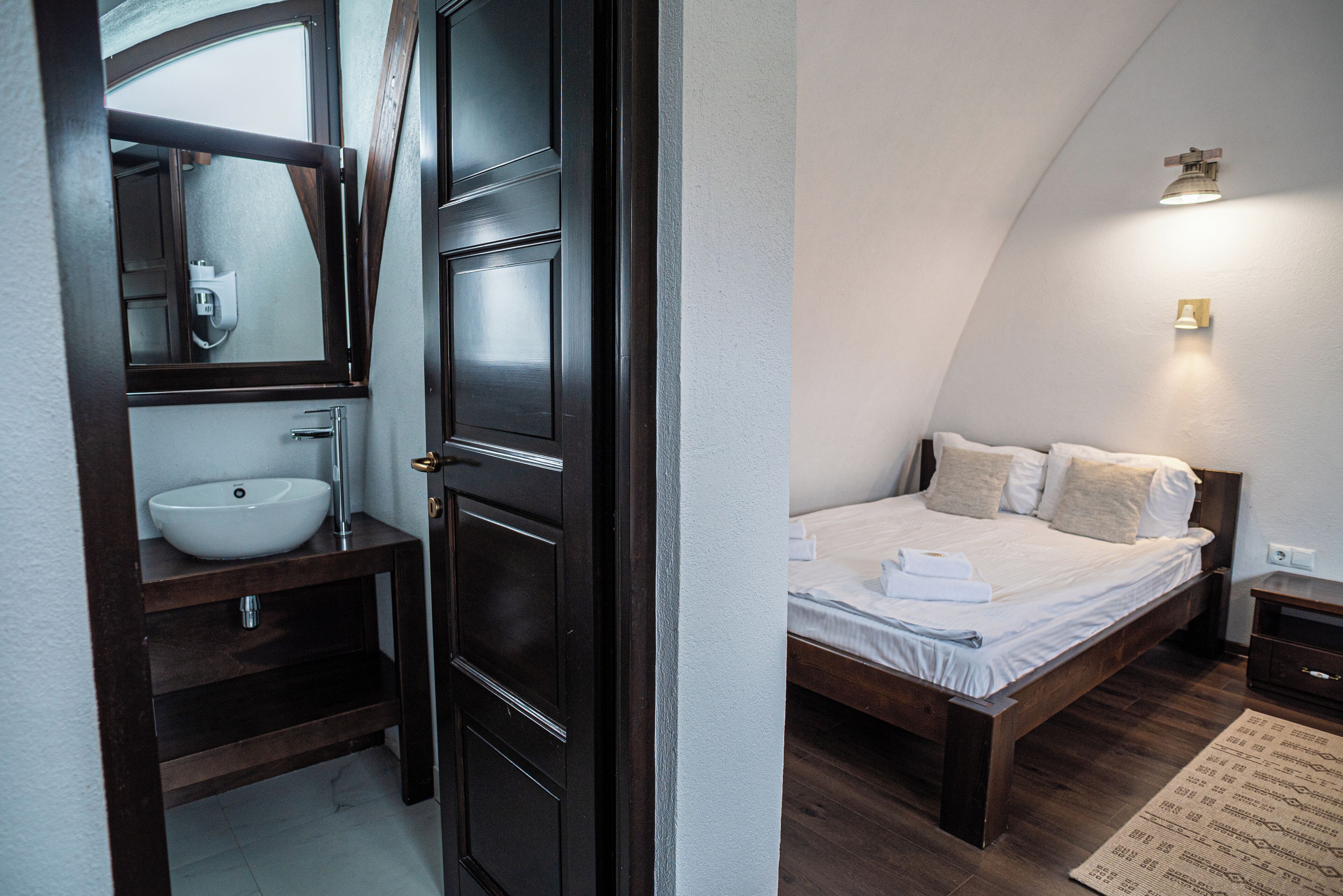 Un dormitorio con cama, mesita de noche y velador.