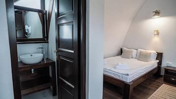 Un dormitorio con cama, mesita de noche y velador.