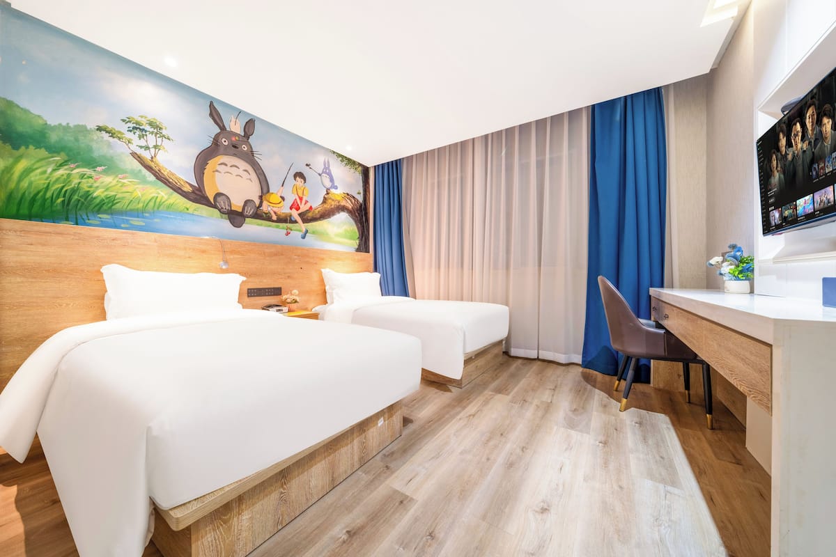 Una habitación de hotel con una cama grande, un escritorio, una silla y un televisor.