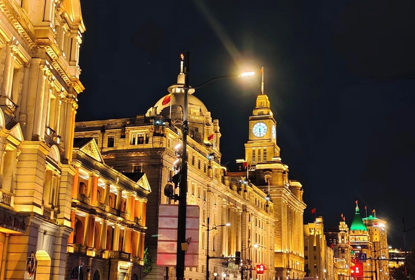A historic building with classical architecture, a prominent clock tower, and illuminated facades.