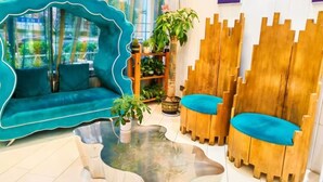A teal sofa, wooden chairs, a glass coffee table, and a plant shelf. - JinglaiHotel SouthBundXintiandi Branch (Shanghai)