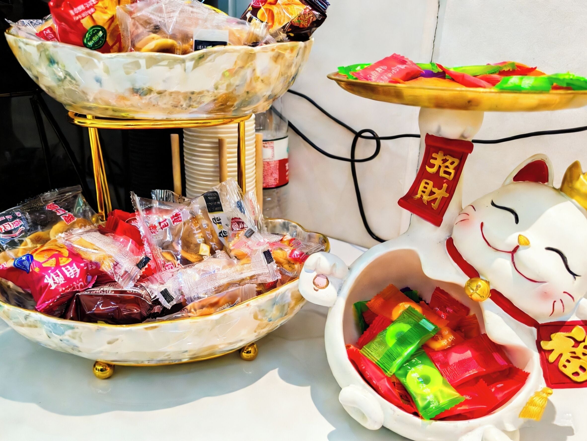 A table with various packaged snacks and a decorative cat figure.