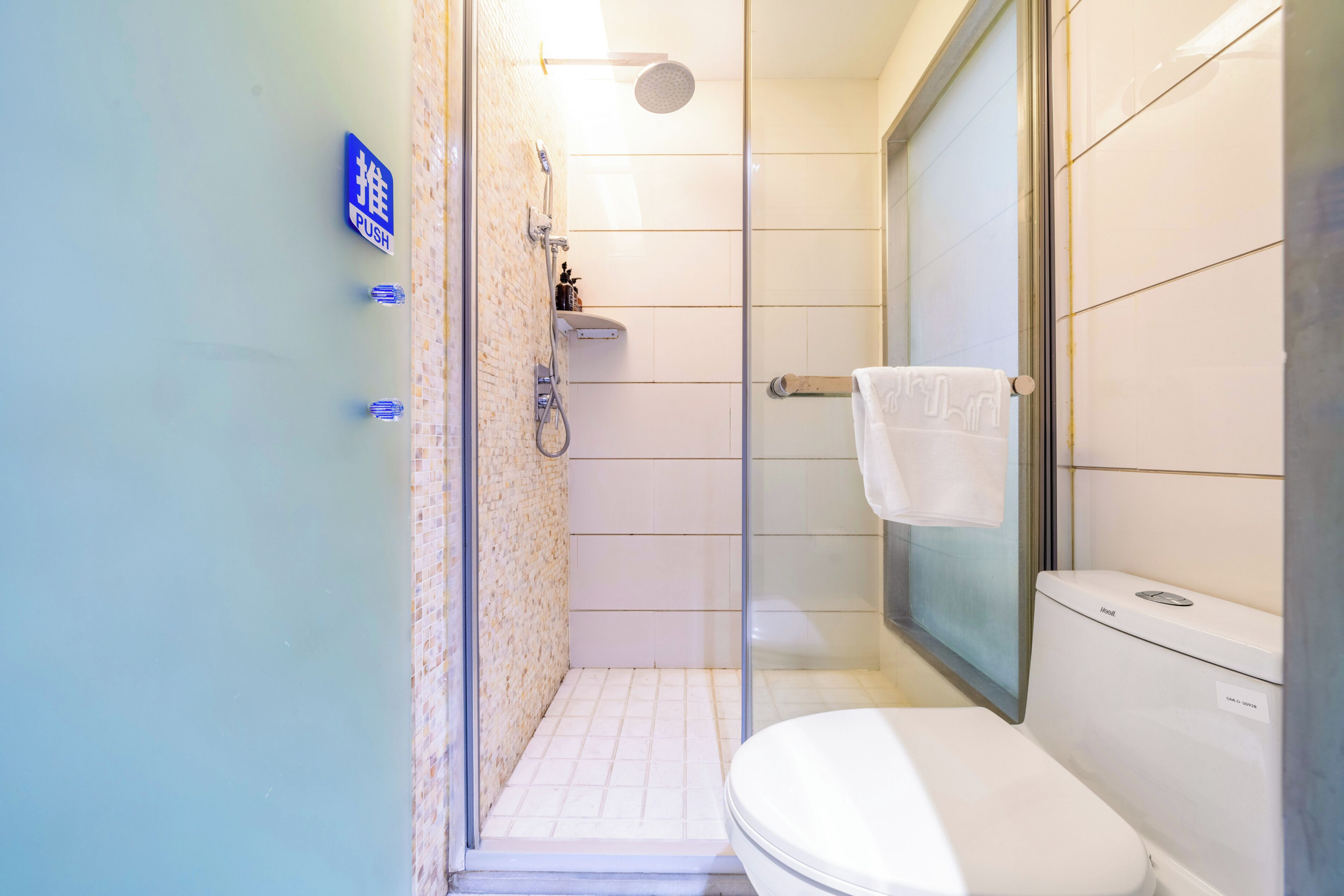 Une salle de bain équipée de toilettes, d’une douche et d’un espace de douche vitré.