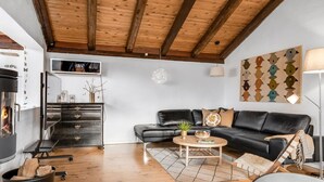 A modern living room with a black leather sofa, wooden coffee table, and a fireplace. - "Klint" - 400m from the sea by Interhome (Hals)