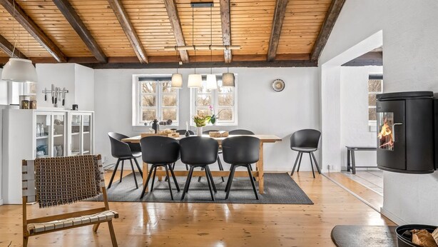 A modern interior with a dining area, wooden ceiling beams, and a fireplace. - "Klint" - 400m from the sea by Interhome (Hals)