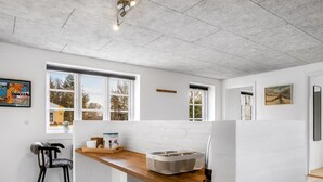 A modern kitchen with white brick walls, wooden countertops, and large windows. - "Klint" - 400m from the sea by Interhome (Hals)