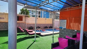 A covered outdoor pool area with lounge chairs and a small pool. - Tafetta Boutique Hotel  (Abuja)