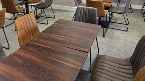A conference room with tables and chairs, a large aquarium wall, and a logo on the wall. - Icon Hotel  (Luton)
