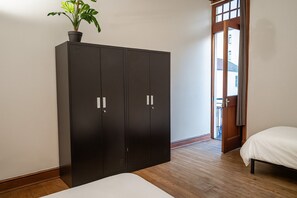 Una camera da letto con un letto, un armadio e una pianta in vaso.