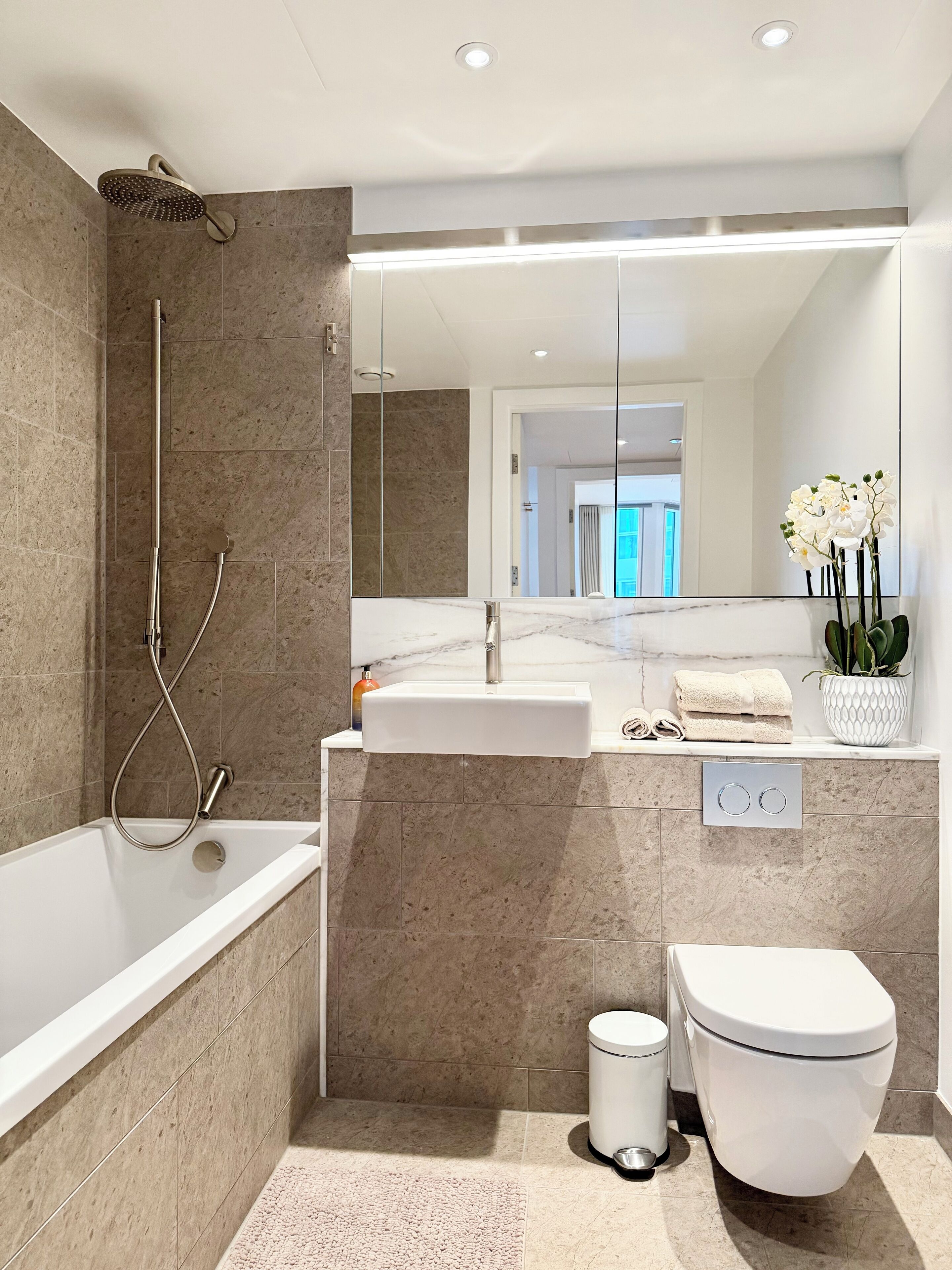 Un baño moderno con bañera, ducha, lavabo e inodoro.
