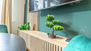 Ein moderner Arbeitsbereich mit einem Holzerreptionstresen, einem Bonsai-Baum und einem flachbildschirmfernseher an der Wand.