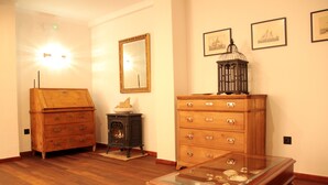 Een kamer met houten meubels, een tafel met glazen blad en decoratieve objecten, en wanddecoraties.