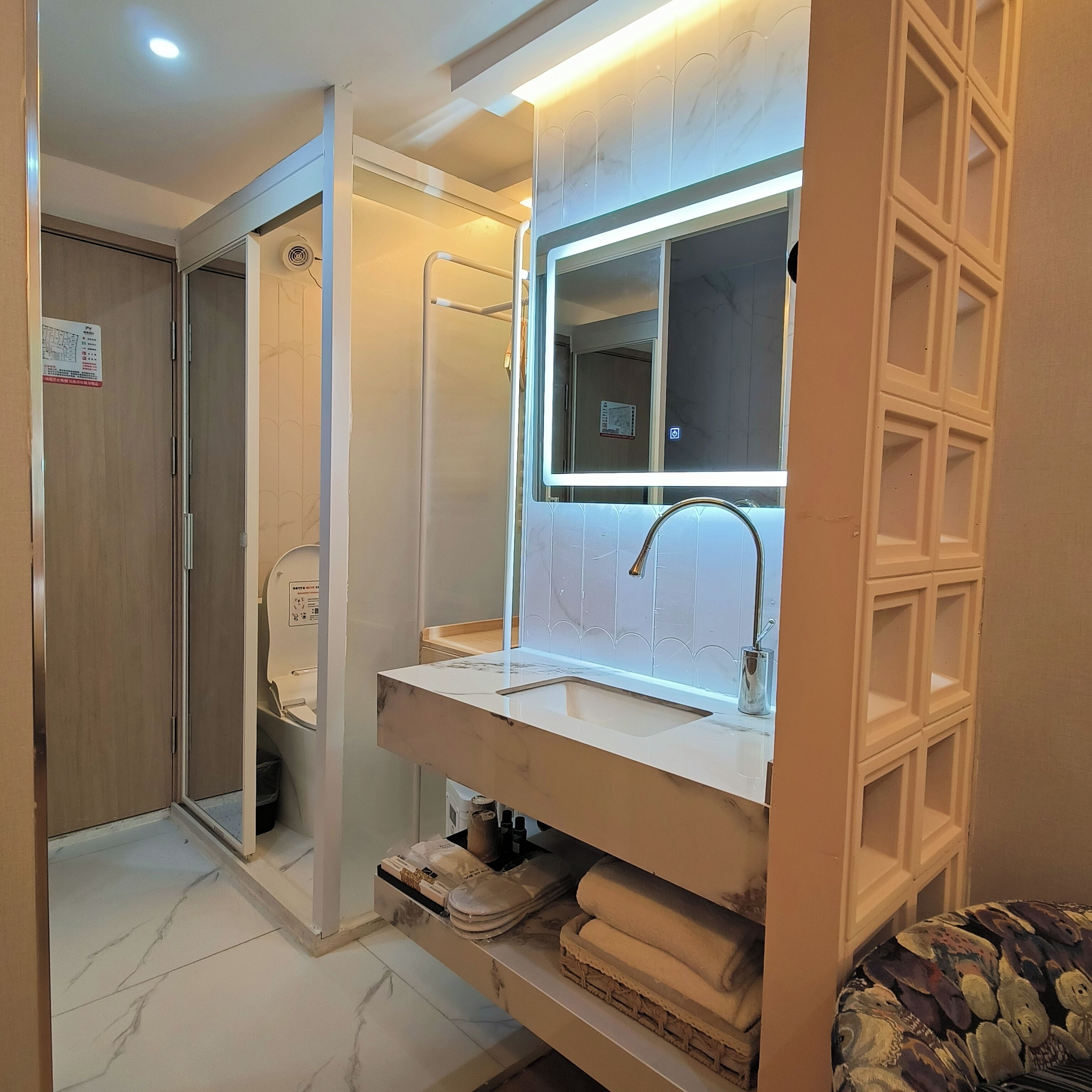 A modern bathroom with a vanity, a mirror, a shower, and a toilet.