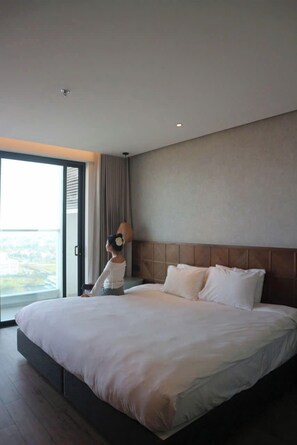 Ein Hotelzimmer mit einem großen Bett, Blick durch eine Schiebetür und modernem Design.