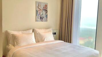 Un dormitorio moderno con una cama grande, un cuadro en la pared y vistas a través del ventanal.