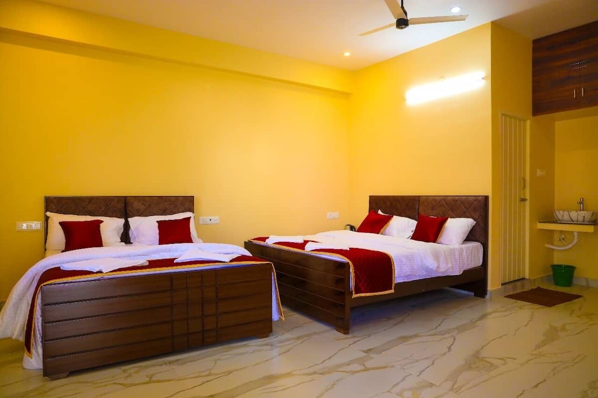 A hotel room with two beds, a ceiling fan, and a bathroom with a sink and mirror.