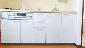 Una cocina con armarios blancos, un microondas y un lavabo.