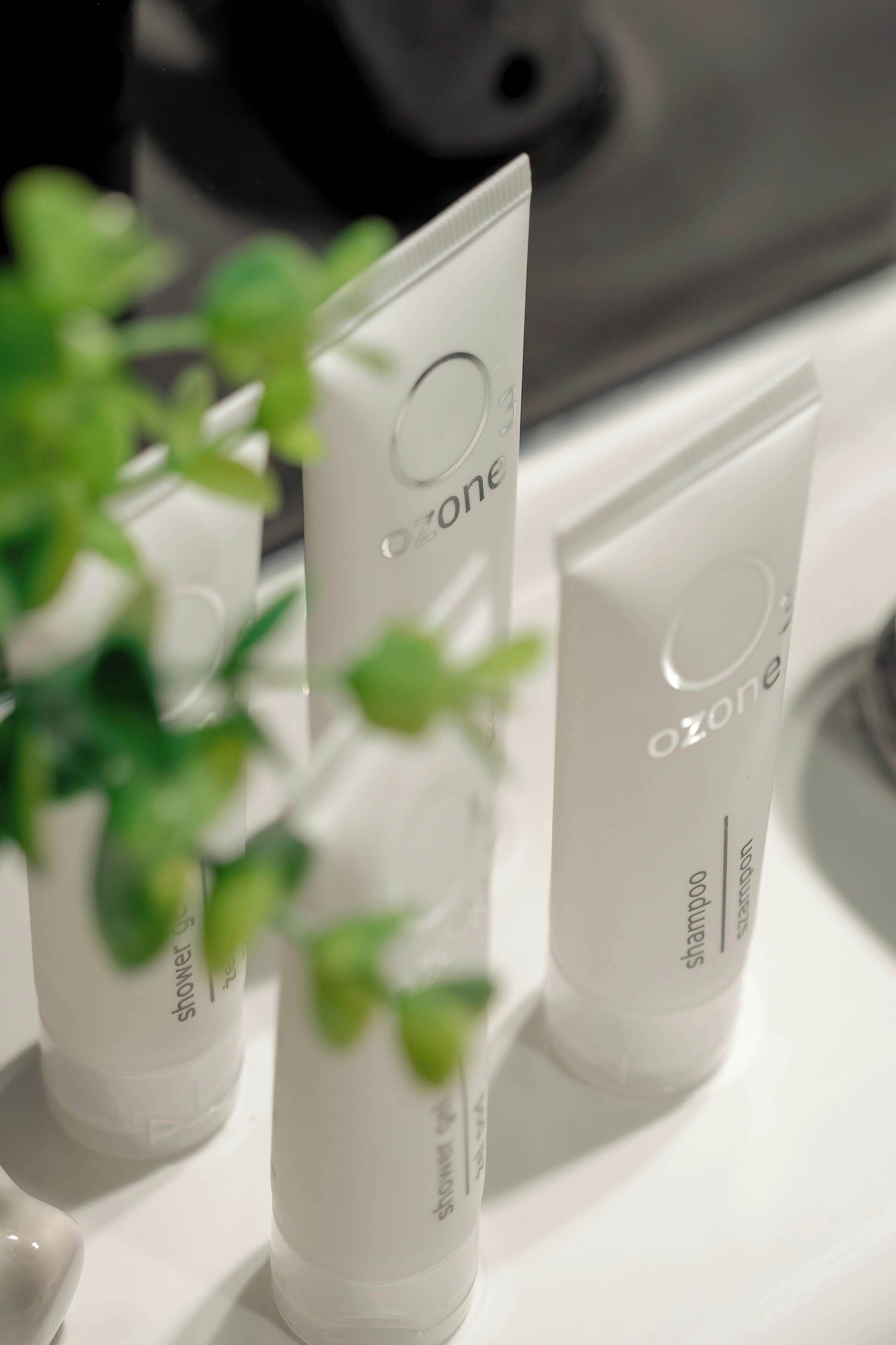 Tres tubos blancos con la etiqueta 'ozone' sobre una superficie blanca.