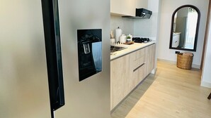 Una cocina moderna con refrigerador empotrado, armarios de madera y una campana extractora de acero inoxidable.