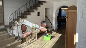 A staircase leading to a second floor, a dining area with a table and chairs, and a hallway with a wooden door. - House Anna Alpirsbach (Alpirsbach)