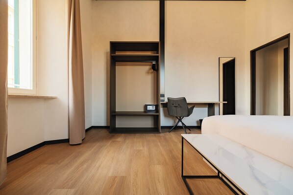 Une chambre d’hôtel moderne équipée d’un lit, d’un bureau et d’une armoire.